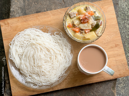 Noolappam Idiyappam rice noodles, a popular traditional steam cooked Kerala breakfast dish with hot and spicy beef stew curry on a houseboat, Alleppey, India. South Indian food. noolputtu Sri lankan photo