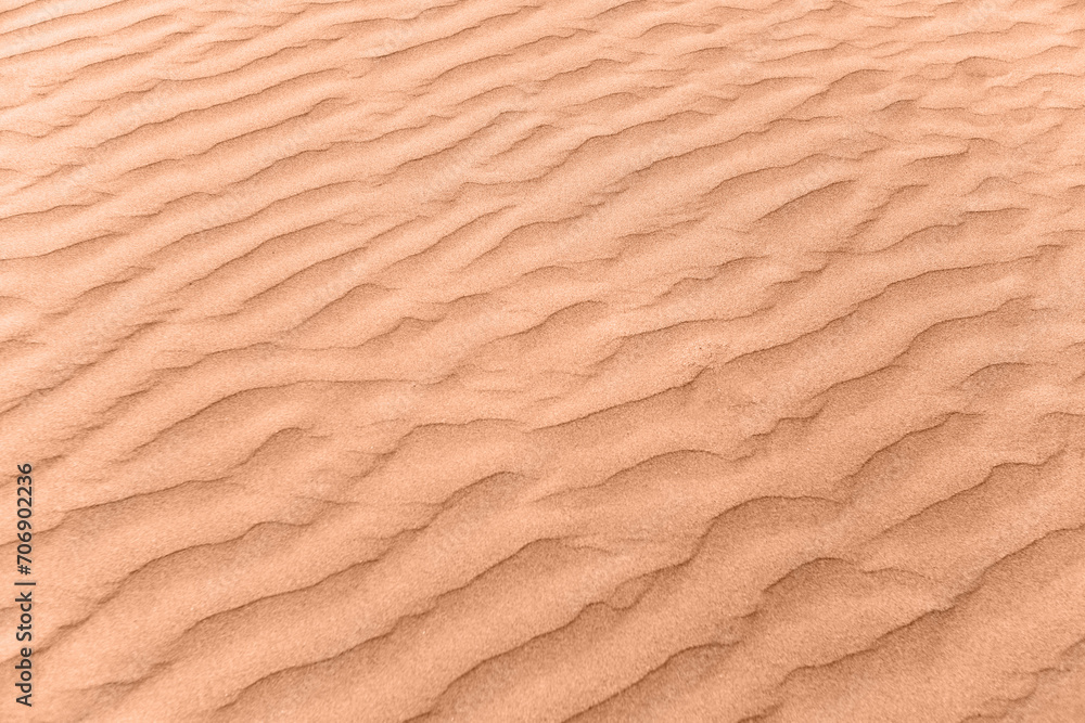 closeup of sand pattern of a beach in the summer. New trending PANTONE Peach Fuzz colour of 2024 year closeup of sand pattern of a beach in the summer. New trending PANTONE Peach Fuzz colour of 2024 year