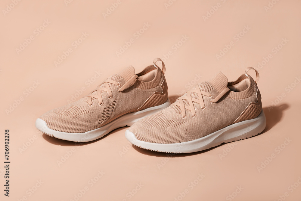 Pink pastel color sneakers on background. New trending PANTONE Peach Fuzz colour of 2024 year