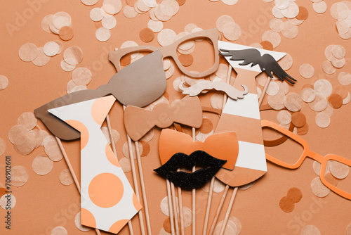Photo booth props glasses, mustache, lips on a pink background flat lay. New trending PANTONE Peach Fuzz colour of 2024 year