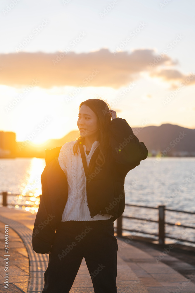 Fototapeta premium 夕暮れの海にいる女性