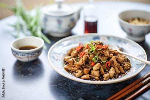 kung pao chicken beside a bowl of soy sauce photo