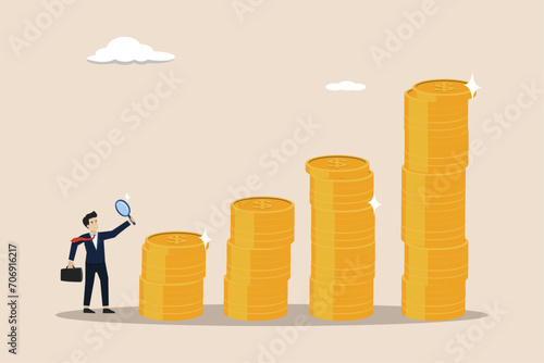 Searching for investment opportunity and earning concept, financial success or salary raise, curios businessman with magnifier inspect and follow money coins trail.