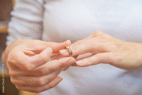 Close-up of woman's hands holding wedding ring. Focus on ring