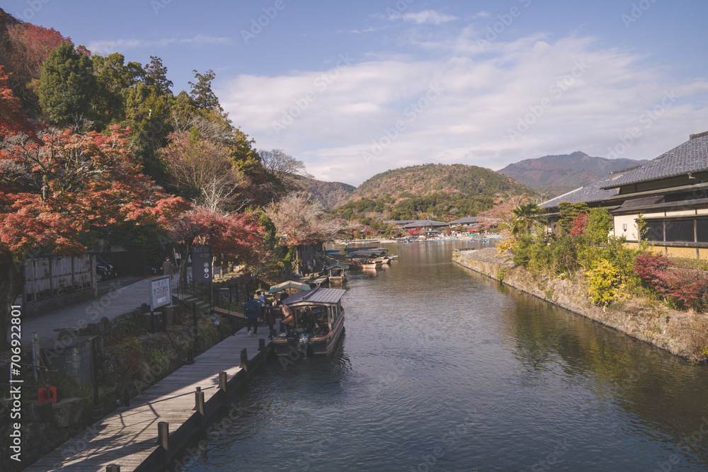 Arashiyama in autumn season along the river in Kyoto, Japan, Aerial view Arashiyama Togetsu or Togetsukyo bridge ancient architecture and boats in Katsura river, Arashiyama, Kyoto, Japan, Asia.
