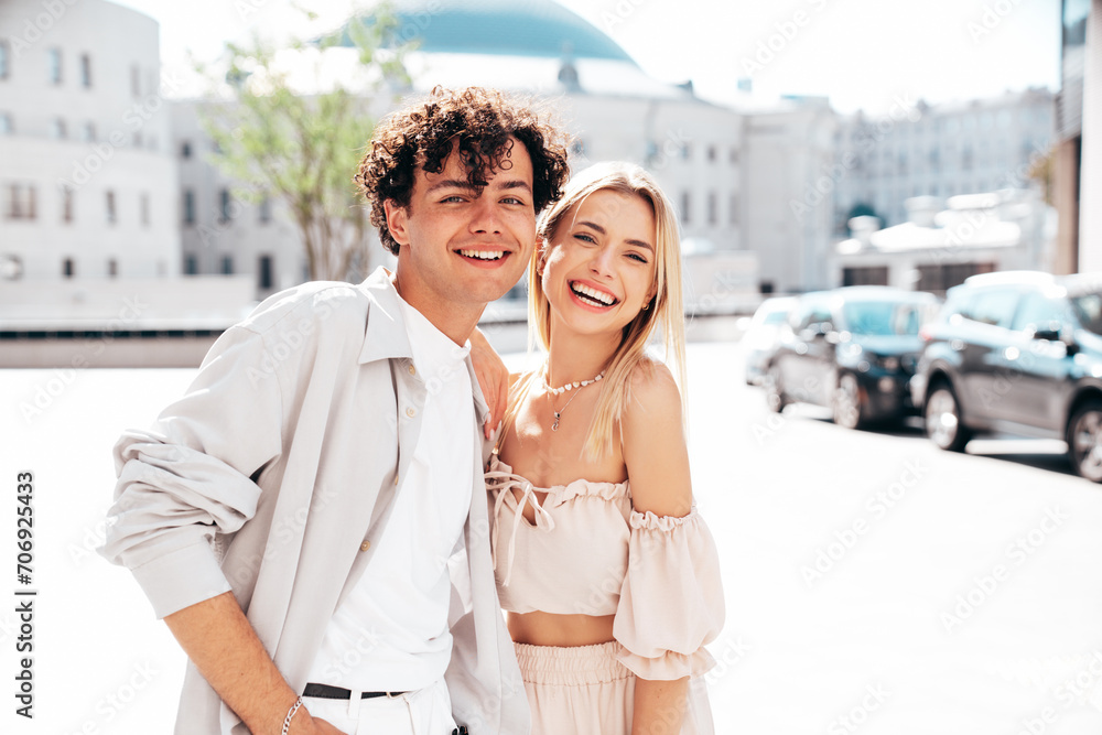 Young smiling beautiful woman and her handsome boyfriend in casual summer clothes. Happy cheerful family. Female having fun. Couple posing in the street background at sunny day