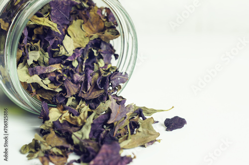 Dry basil leaves green and purple in a glass jar