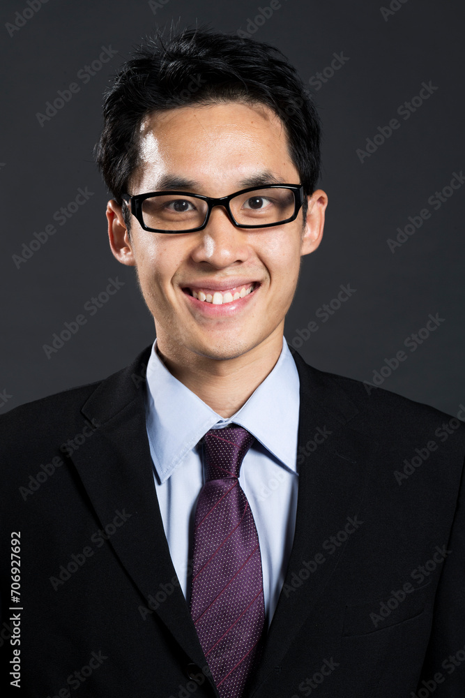 Stylish Chinese business man. In front of dark background Stylish Chinese business man. In front of dark background