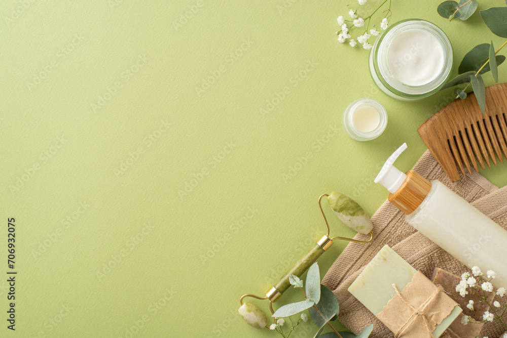 Organic bodycare and hygiene layout. Top view gua sha roller, skincare items, natural hairbrush, handmade soap, bath towel, eucalyptus, gypsophila on soft green backdrop, perfect for text or promotion