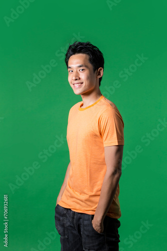 Portrait of Chinese man standing against green background.