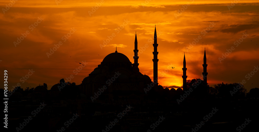 Silhouette of Suleymaniye Mosque at sunset. Golden sky and clouds.