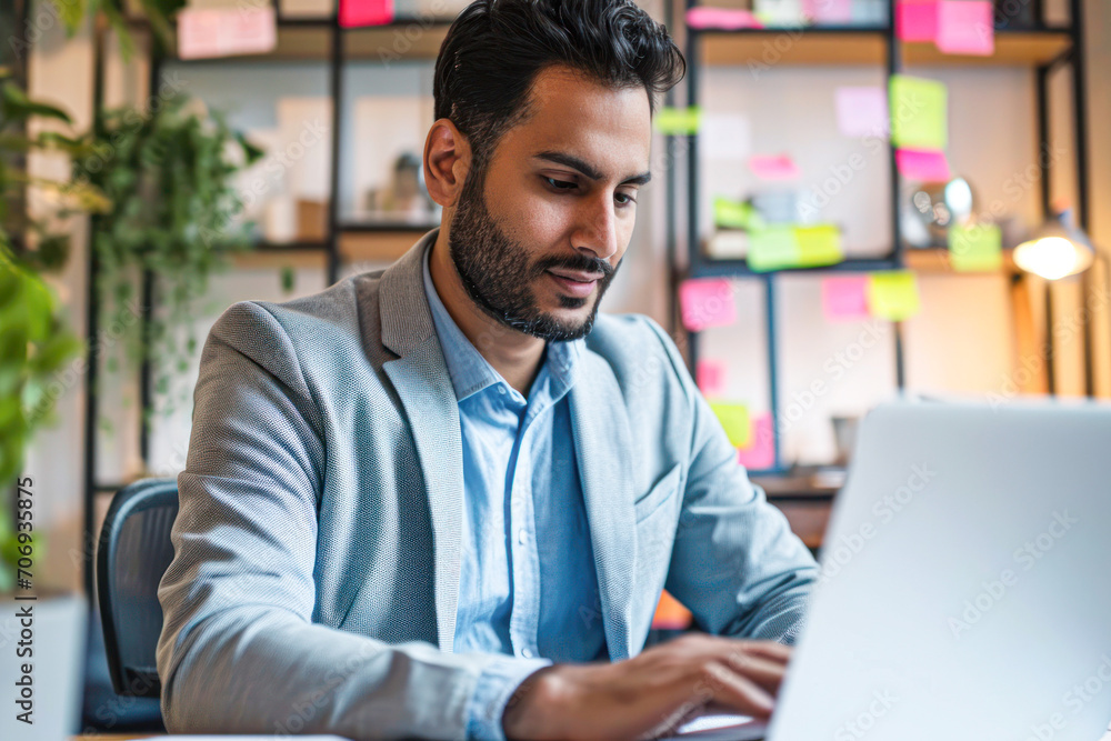 Young businessman using laptop in his office. Handsome man working on the project. Young businessman using laptop in his office. Handsome man working on the project.