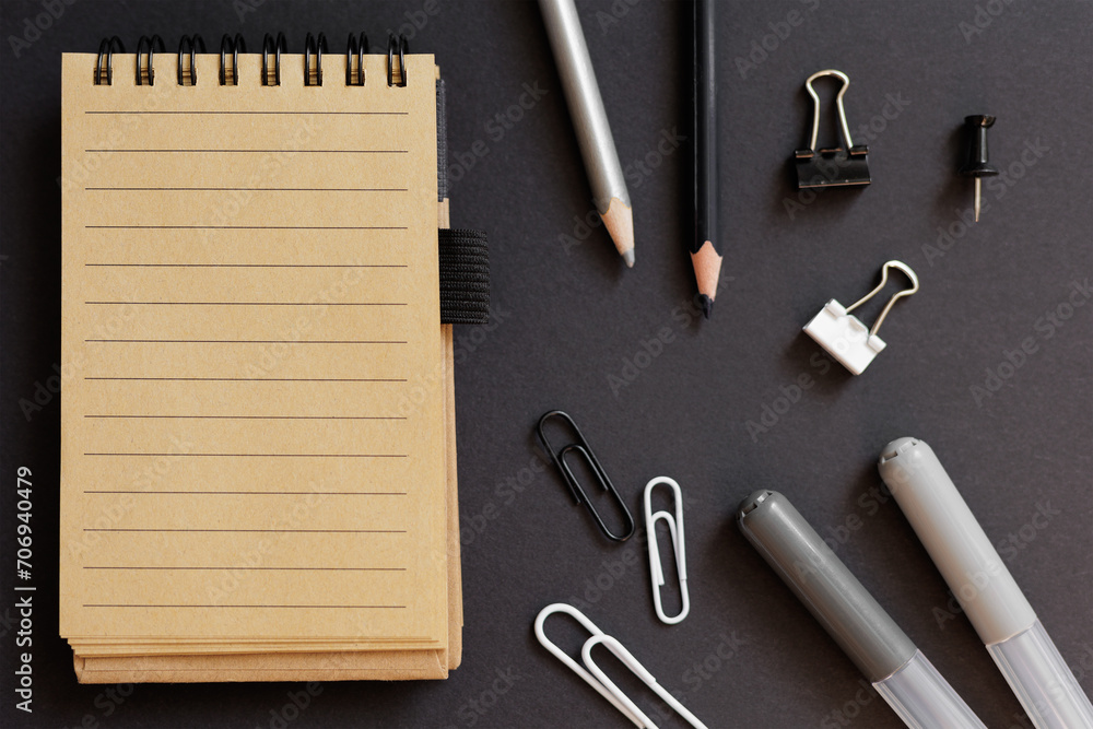 top view of school stationery with notepad over black top view of school stationery with notepad over black