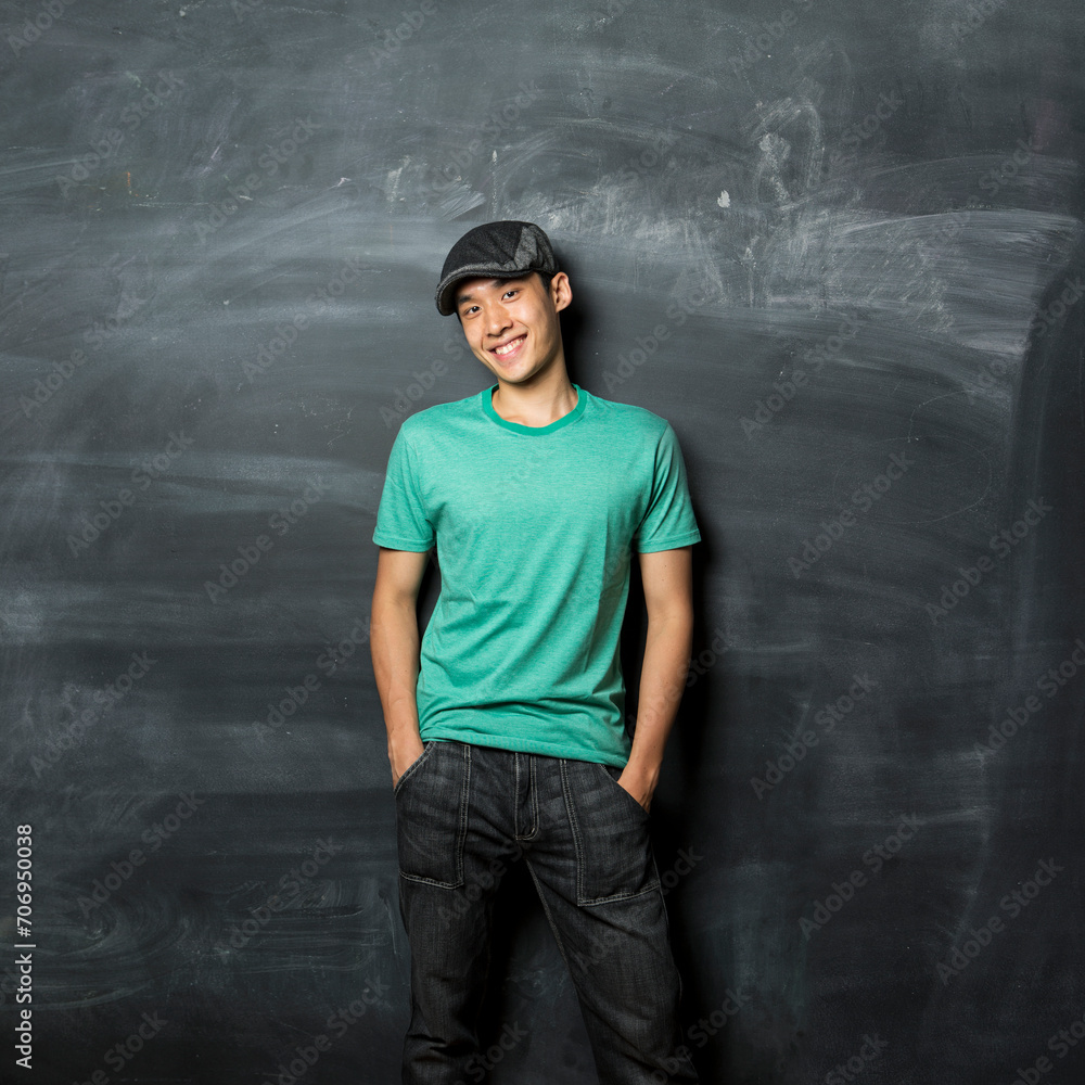 Happy Asian man standing next to a blackboard. Happy Asian man standing next to a blackboard.