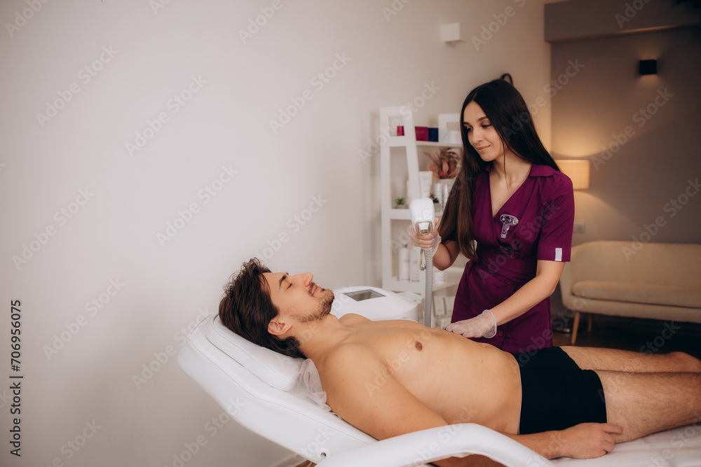 Close-up Of Female Worker Giving Man Laser Epilation On Chest In Salon Close-up Of Female Worker Giving Man Laser Epilation On Chest In Salon