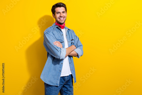 Photo portrait of handsome young guy crossed hands confident pose wear trendy jeans outfit isolated on yellow color background