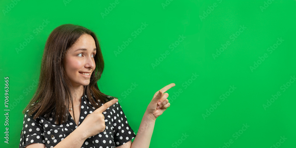 Woman pointing at a green cardboard empty background - copy space for text. Woman pointing at a green cardboard empty background - copy space for text.