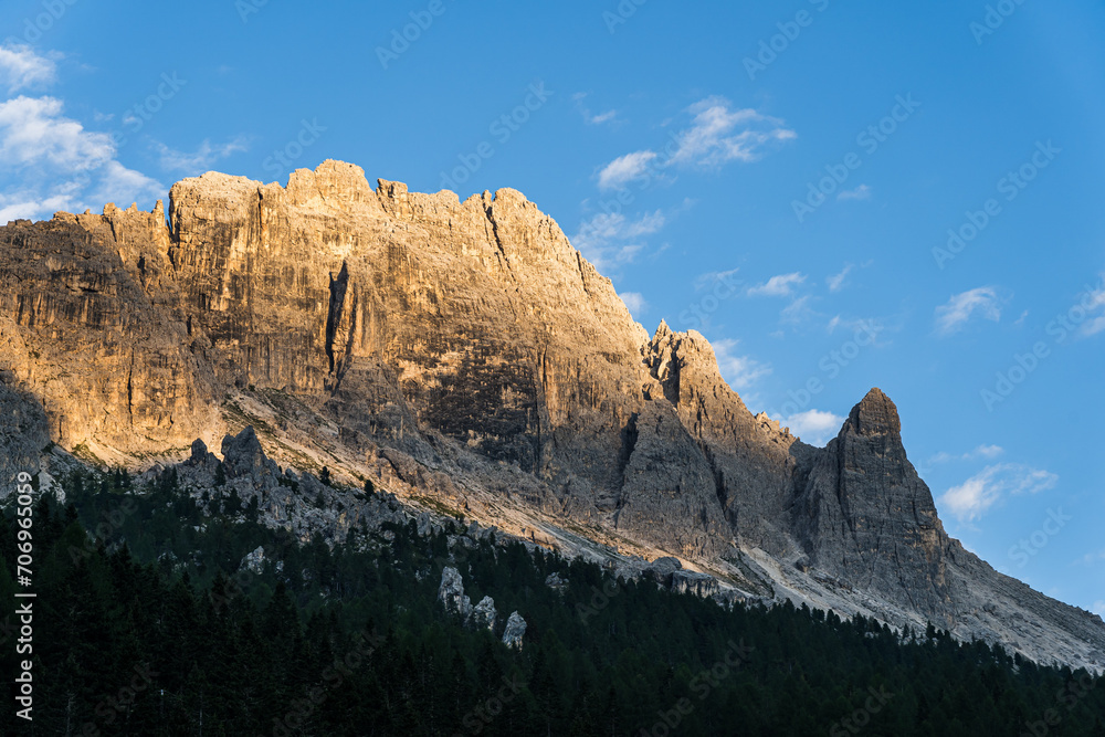 Fototapeta premium Dolomite peak hit by the last sun rays in the evening with blue sky in the background