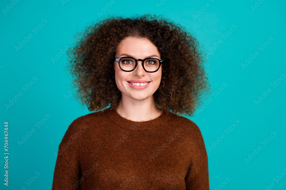 Photo portrait of young smiling friendly hr manager in glasses also wearing brown jumper fits her look isolated on blue color background Photo portrait of young smiling friendly hr manager in glasses also wearing brown jumper fits her look isolated on blue color background