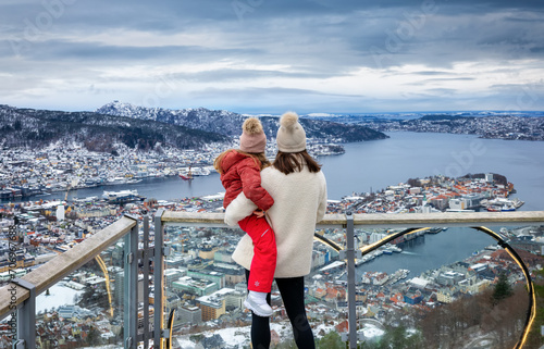 A mother and her daughter enjoying the winter view of the cityscape of Bergen, Norway, from a viewpoint