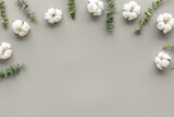 Flowers composition on gray desk with eucalyptus branches and cotton. Flat lay, top view, copy space