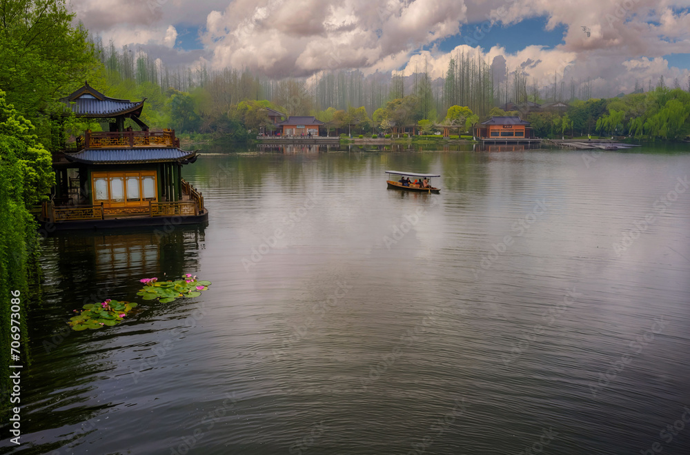 Fototapeta premium Traditional East Asian Pavilion Over Water, Boatman Rowing, Urban Skyline in Distance, Serene Nature Scene