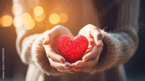 Hands of a woman holding and offering a heart shape