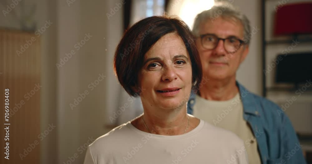 Portrait of a middle-aged couple, indoors.
The woman looks into the camera and the man steps forward and hugs his wife. Portrait of a middle-aged couple, indoors.
The woman looks into the camera and the man steps forward and hugs his wife.