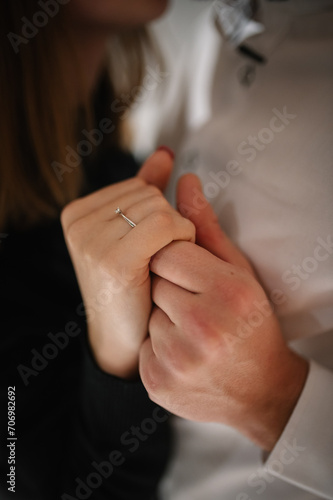 Engagement ring. Man in love putting a ring on woman finger. Propose. Closeup hands. Offer of hand and heart. Man making a marriage proposal to his woman. Engaged couple on Valentine's Day evening.