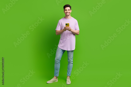 Full length photo of nice glad man dressed purple stylish clothes isolated on green color background © deagreez