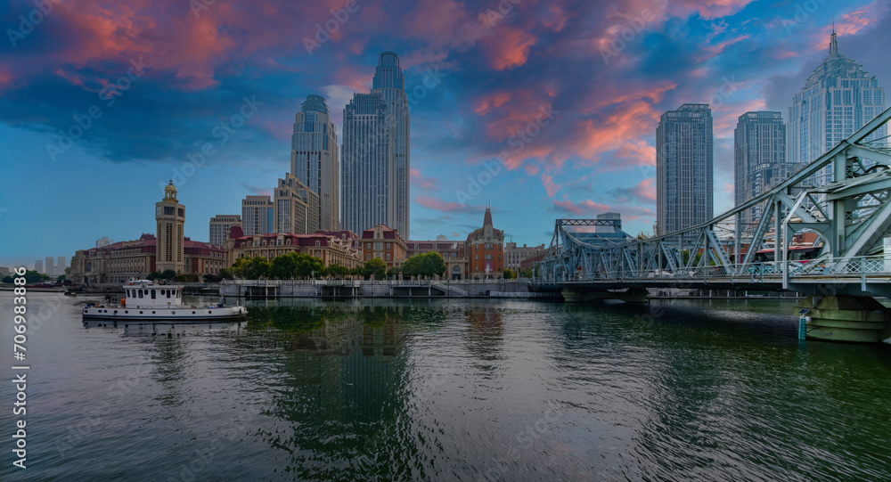 Serene Urban Dawn with Historic Clock Tower, Reflective Waterfront, and Iconic Bridge