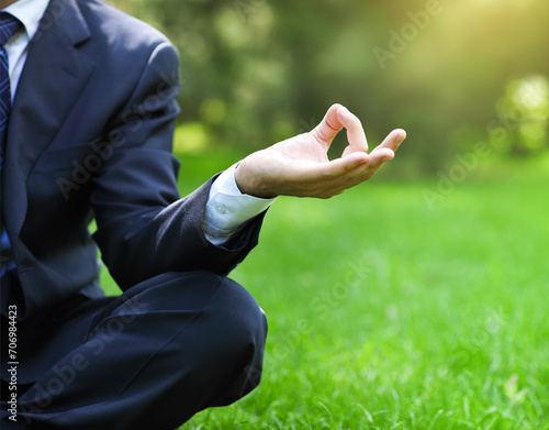Business man relax in a park in the lotus position