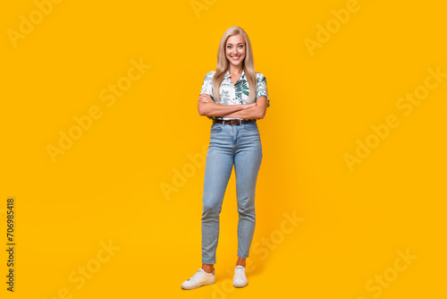 Full length photo of good mood gorgeous woman wear stylish blouse denim pants hold arms crossed isolated on yellow color background