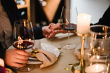 Romantic date by candlelight at night. Proposal hand and heart. Hands man and woman hold glasses at home. Toast. Couple in love drinking wine. Cheers. Dinner setup table for couple on Valentine's day.