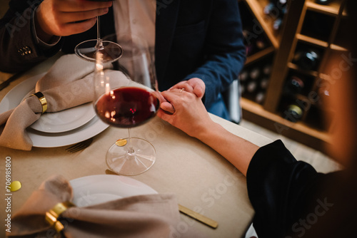 Romantic date by candlelight at night. Proposal hand and heart. Hands man and woman hold glasses. Couple in love drinking wine. Dinner setup table for couple. Will you marry me. She said yes. Top view photo