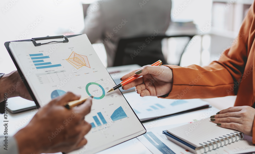Meeting of business people pointing at graph. Group of businesspeople discussing together at a meeting. Meeting of business people pointing at graph. Group of businesspeople discussing together at a meeting.