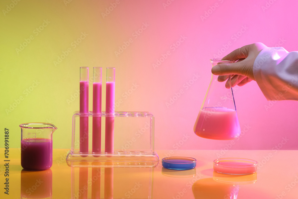 Front view of a table in the laboratory featured different types of glassware containing colorful chemical. Science laboratory test tubes, lab equipment for research new medical Front view of a table in the laboratory featured different types of glassware containing colorful chemical. Science laboratory test tubes, lab equipment for research new medical