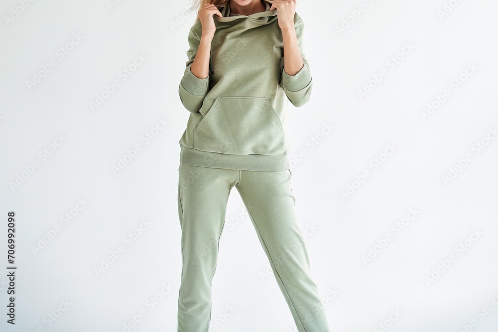 Horizontal studio photo for sports clothing sale. Model Showcasing a Stylish and Comfortable Outfit Perfect for Everyday Wear. A Girl wears a light green hoodie and pants Horizontal studio photo for sports clothing sale. Model Showcasing a Stylish and Comfortable Outfit Perfect for Everyday Wear. A Girl wears a light green hoodie and pants