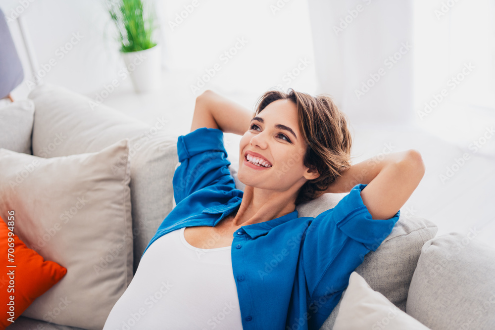 Portrait of pretty cheerful girl sit cozy girl toothy smile hands behind head contemplate enjoy morning harmony apartment indoors Portrait of pretty cheerful girl sit cozy girl toothy smile hands behind head contemplate enjoy morning harmony apartment indoors