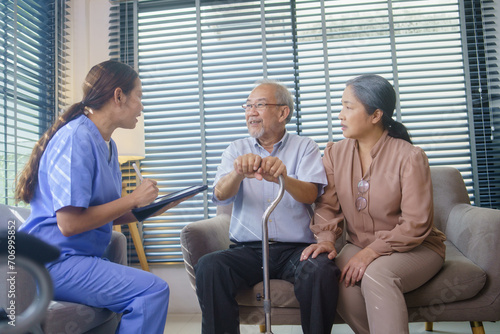 Asian nurse or caregiver visit senior man patient to diagnosis and check up health at home. Physician explain health result to grandfather and grandmother. Healthcare and medical insurance © winnievinzence