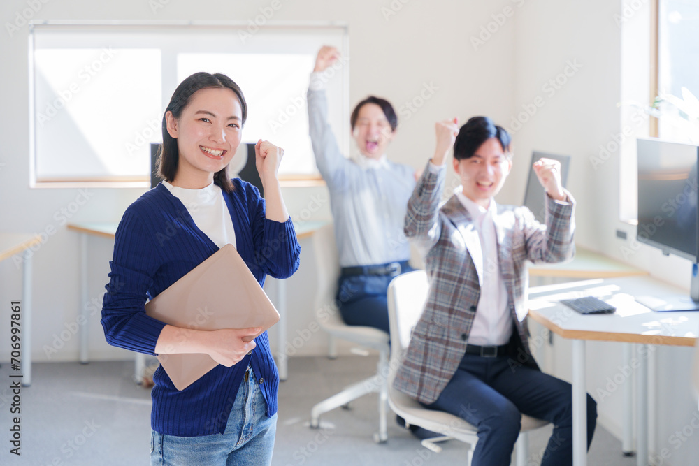 オフィスでガッツポーズするビジネスパーソン オフィスでガッツポーズするビジネスパーソン