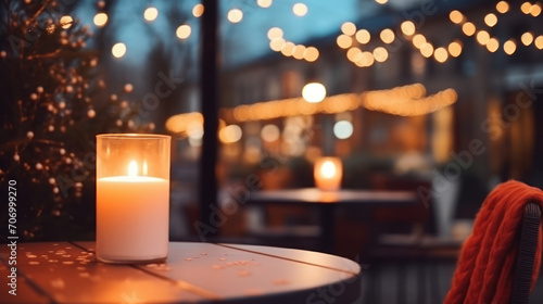 Lit up candle at an outdoor table of a restaurant in winter, cosy atmosphere, selective focus, bokeh. Ai Generative.