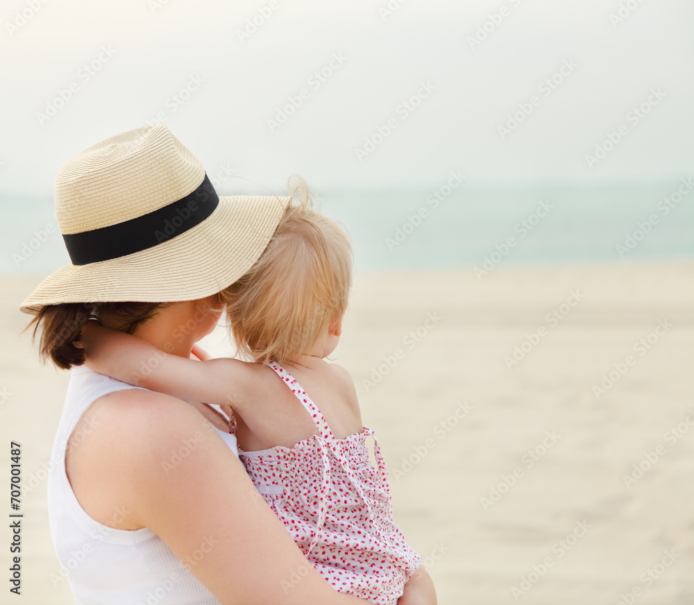 Portrait of mother holding her bay girl at beach