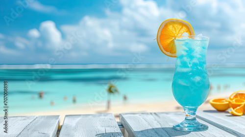 Blue hawaii cocktail on white wooden table with blue sea and sky background.