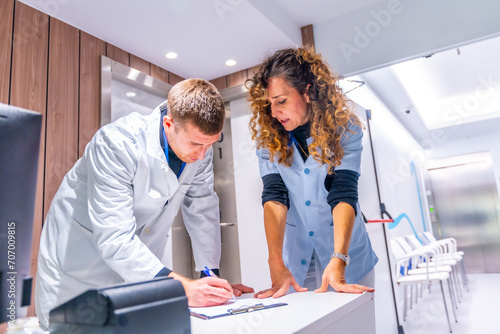 General practitioner doctor filling a form in the hospital photo