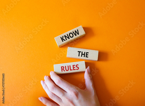 Know the rules symbol. Wooden blocks with words Know the rules. Beautiful orange background. Businessman hand. Business and Know the rules concept. Copy space.