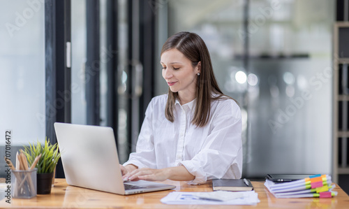 Young business hispanic woman work on laptop desk doing math finance on an office desk  tax  report  accounting  statistics  and analytical research concept