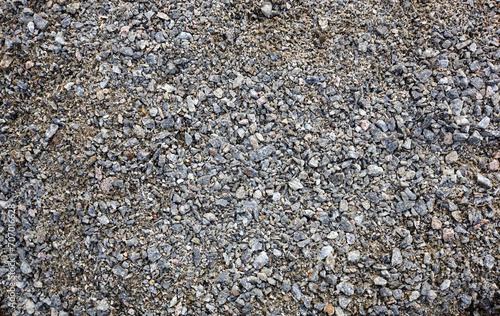 Grey ground stone rubble road background. Natural gray granite chippings, macadam, rubble or crushed stones texture, top view