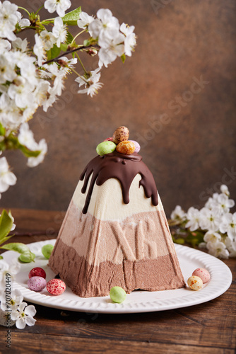 Paskha Cottage cheese traditional Easter dessert with three types of chocolate white, milk and bitter. Decorated with small colorful candies in a shape of Easter eggs. 