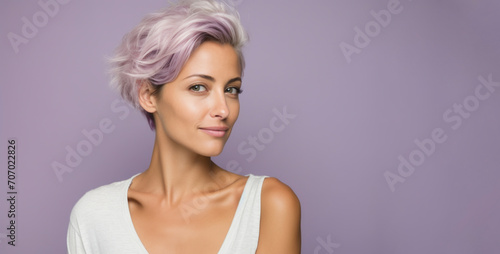 Portrait of a beautiful young woman with pink hair on a purple background.
